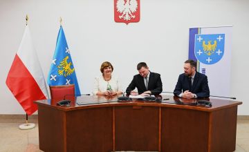 Trzy osoby podczas podpisania umowy